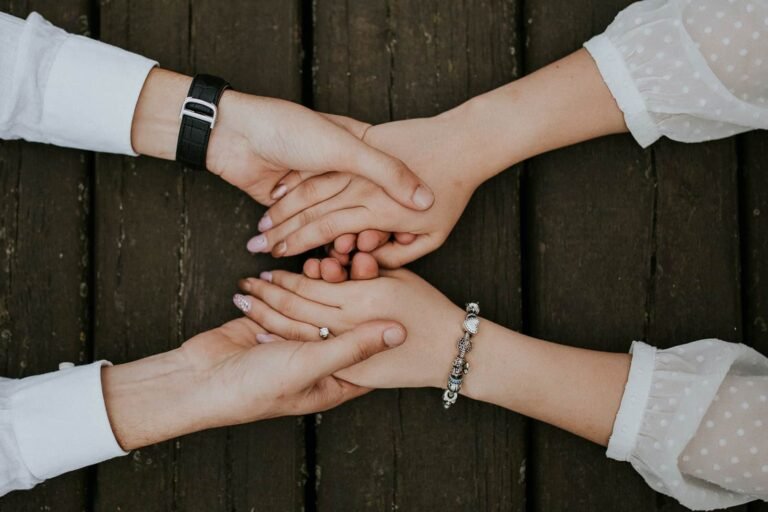 Two pairs of hands clasped together in a gesture of teamwork and partnership.