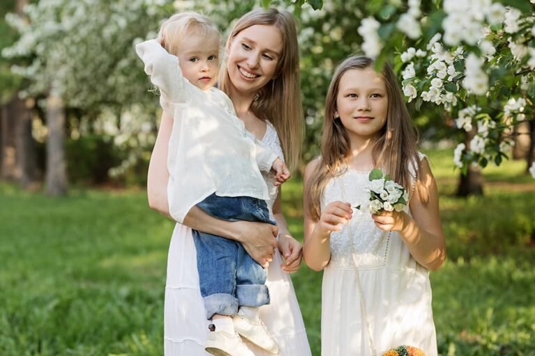 Woman with two children enjoying a sunny outdoor family moment.