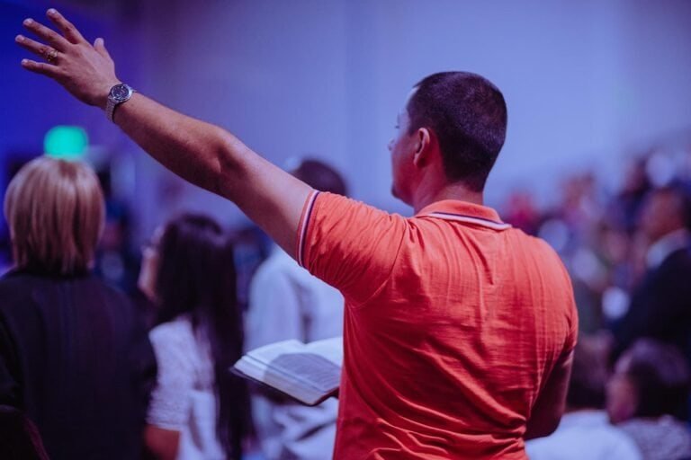 Man raising hand at conference, engaging with audience, blockchain event.