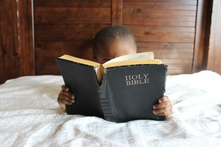 Young child reading the Holy Bible, focusing on faith and spirituality.